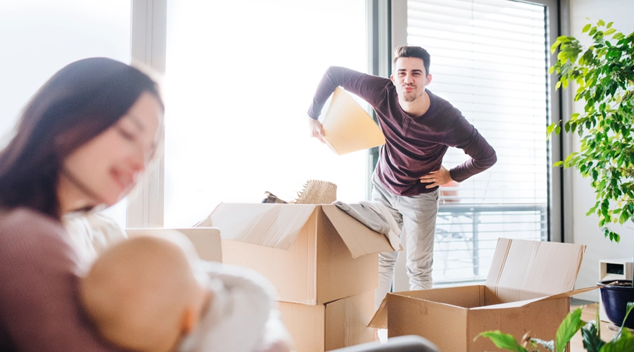 Junge Familie mit Baby beim Einzug in neue Wohnung